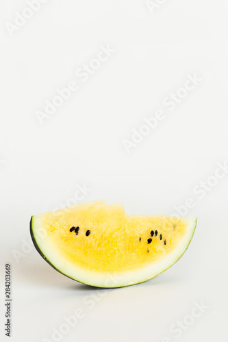 cut a slice of ripe yellow melon on a white background