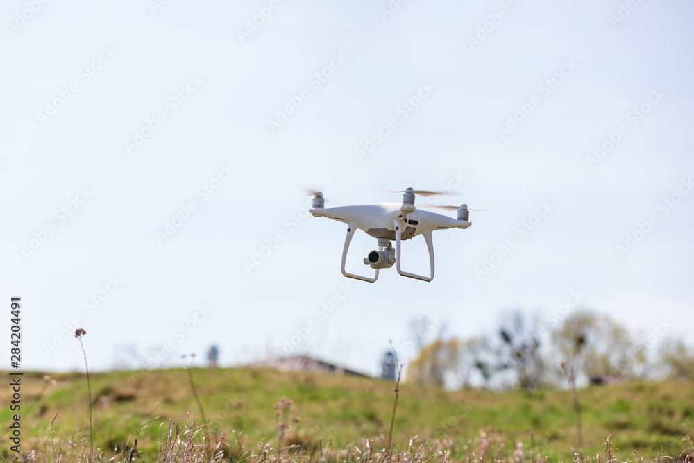 Close up on white drone camera. Drone quadcopter in flight Close up on white drone camera. Drone quadcopter in flight
