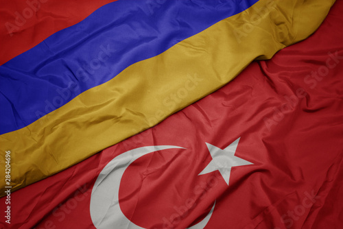 waving colorful flag of turkey and national flag of armenia.