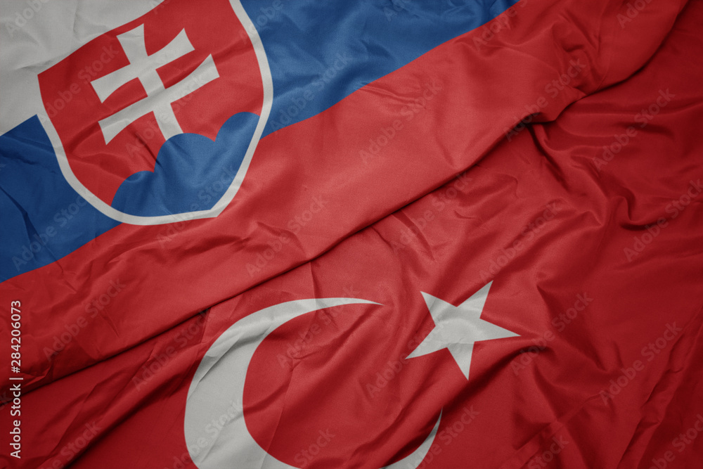Fototapeta premium waving colorful flag of turkey and national flag of slovakia.