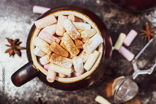 Close up view of hot tasty cocoa drink or hot chocolate with marshmallows on vintage background. Autumn hot drink. photo