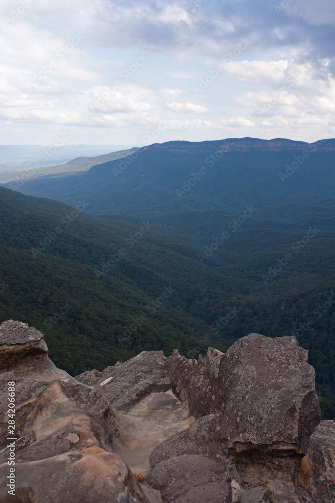 Fototapeta premium A cliff in the foreground with forests in the background at the Wentworth Falls in the Blue Mountains in Australia