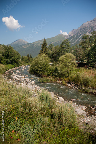 Panorama with mountain river in Italian Alps in summer day