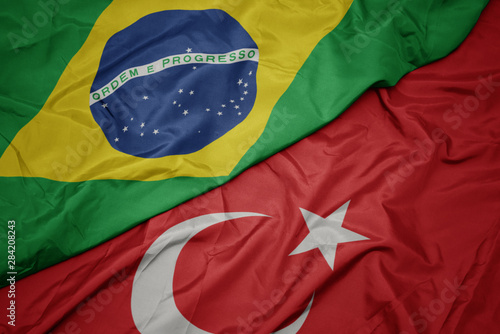 waving colorful flag of turkey and national flag of brazil.