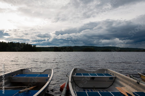 Beautiful view in the evening at the blue hour of row boats at the landing stage at lake Safssjon region Dalarna in Sweden