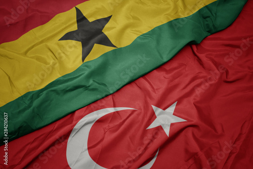 waving colorful flag of turkey and national flag of ghana.