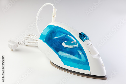 The electric iron stands on a white background