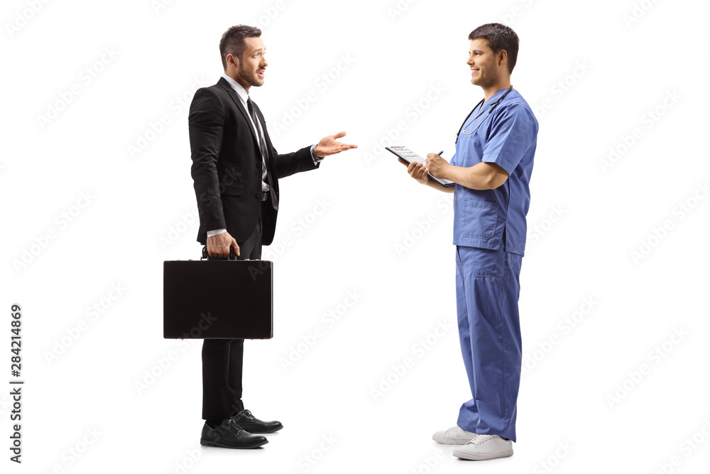Businessman with a briefcase gesturing with hand and talking to a male doctor in a blue uniform Businessman with a briefcase gesturing with hand and talking to a male doctor in a blue uniform