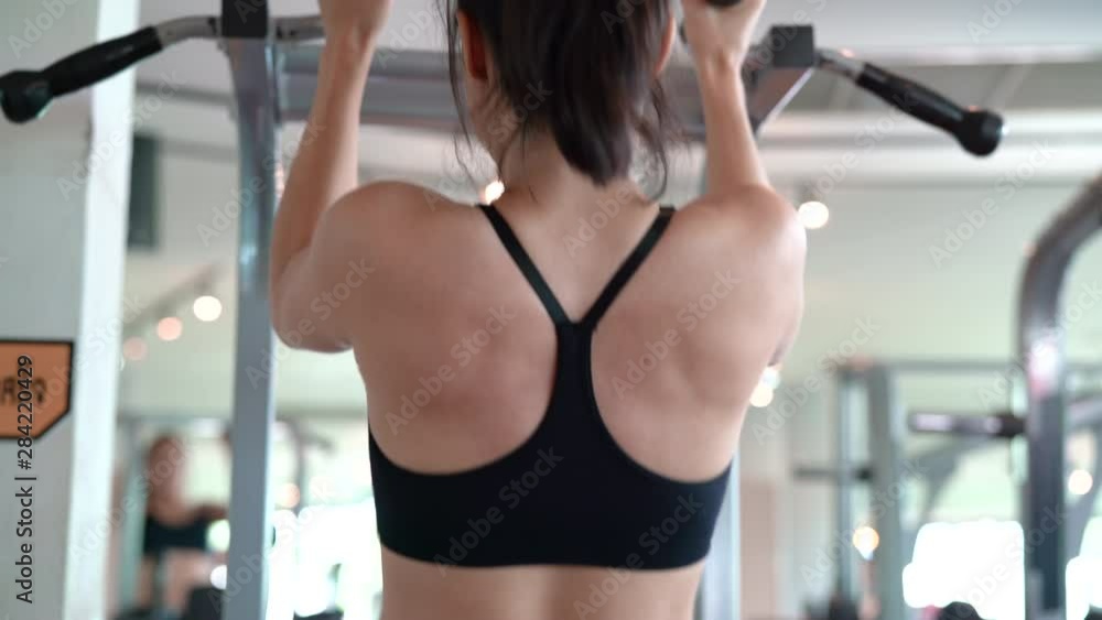 Fitness asian woman workout on the bar pull-up exercise in the fitness gym healthy lifestyle building strong and fit body 4k resolution. Fitness asian woman workout on the bar pull-up exercise in the fitness gym healthy lifestyle building strong and fit body 4k resolution.