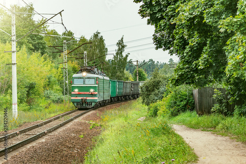 Freight train moves on the countryside background.