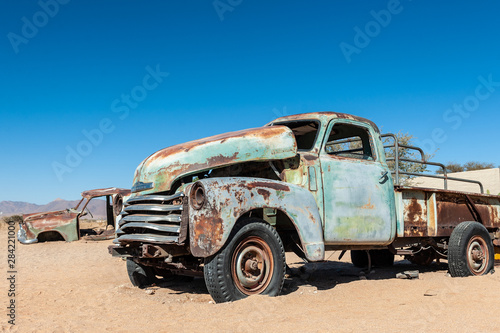 Wrecks of historic cars line the road in the town of Solitaire in the Khomas Region of Namibia.