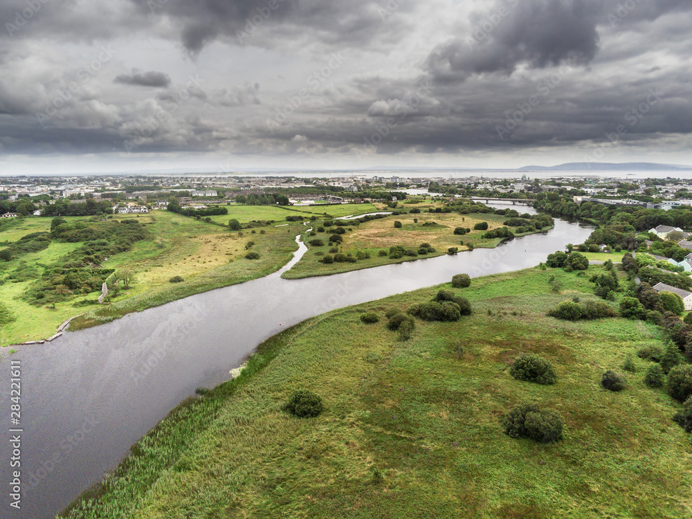 Aerial view on River Corrib, Galway city and bay, Burren mountains in the background, Cloudy sky.