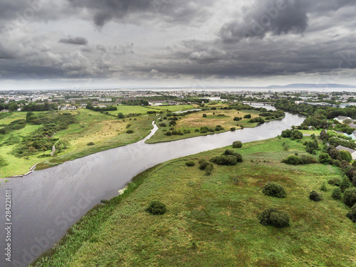 Aerial view on River Corrib, Galway city and bay, Burren mountains in the background, Cloudy sky. © mark_gusev