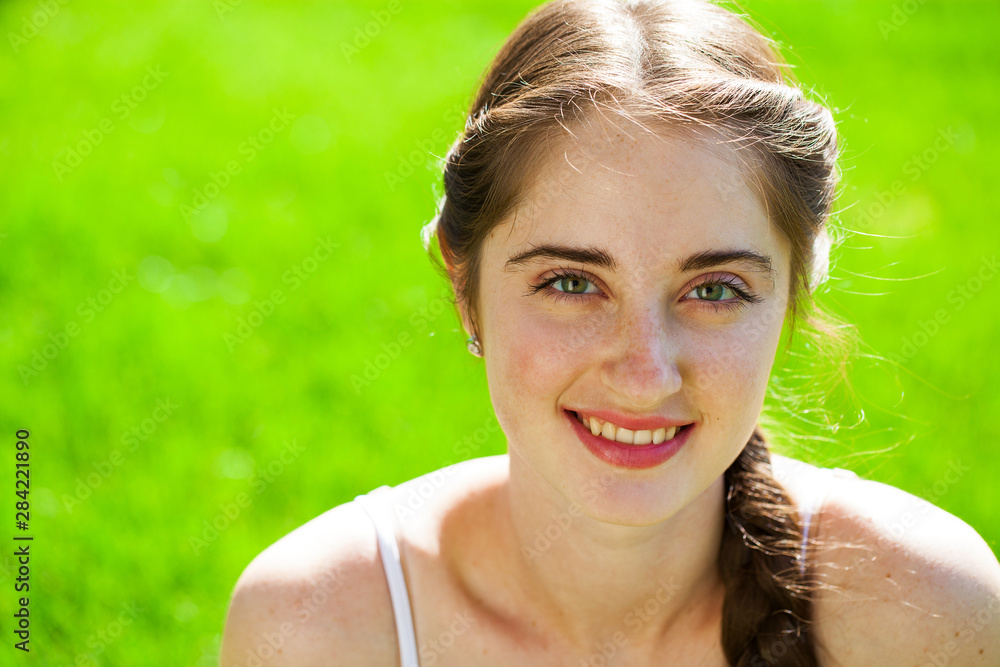 Portrait of a young beautiful brunette woman in on summer park background Portrait of a young beautiful brunette woman in on summer park background