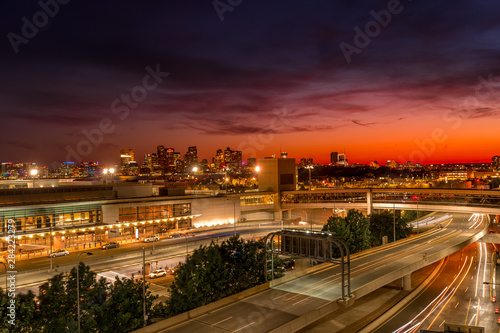 Colorful sunset sky over Boston downtown and Logan airport with cars passing by photo