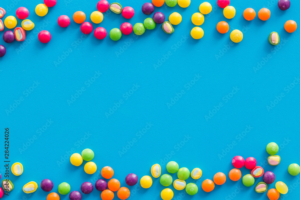 Candies and dots for party design on blue background top view copyspace