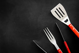 spatula, fork, tongs for barbecue on black background top view mock up
