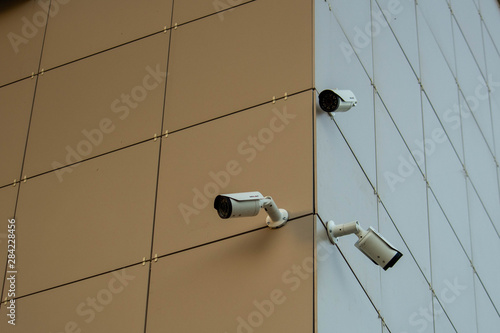 Three cameras on the building, spy view, guard equipment, building, light background