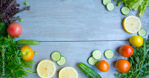 summer salad. cooking salad on a light wood background. different vegetables and greens