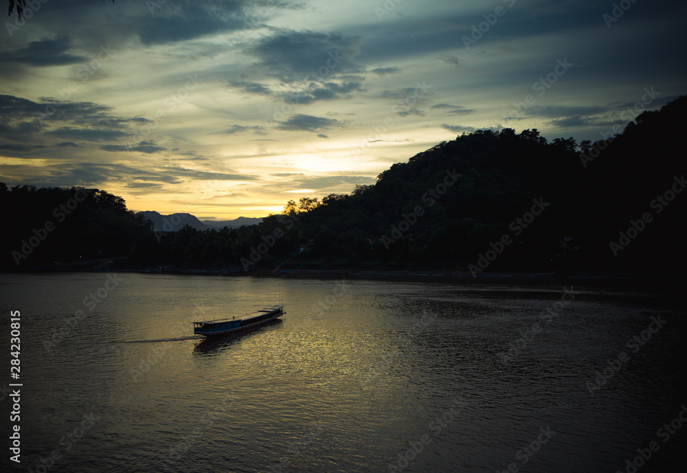 sunset on the river with a boat in southeast of Asia 