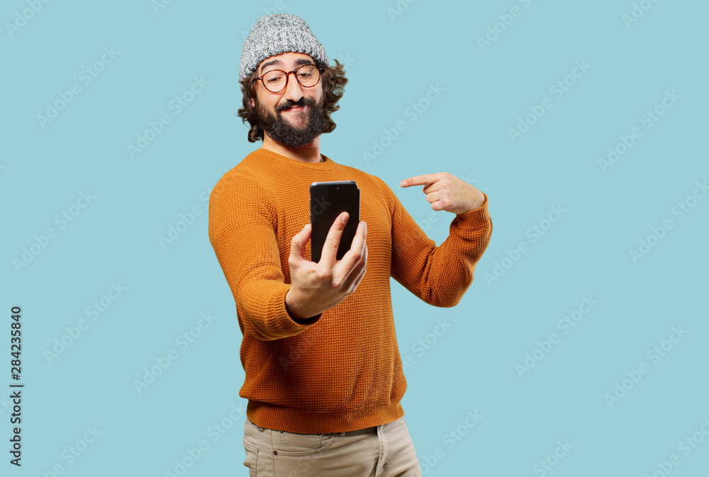 young bearded man with a smart phone - obrazy, fototapety, plakaty 
