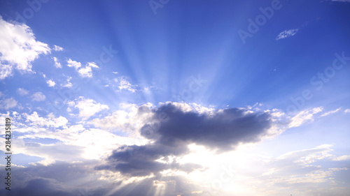 青い空と太陽光を遮る流れる雲