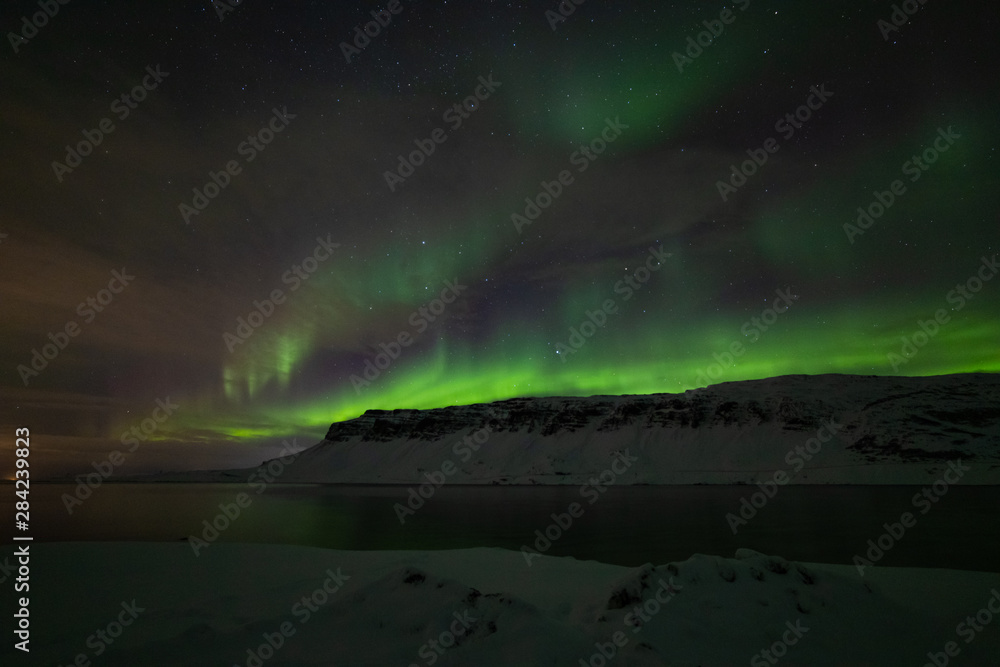 Bright and wavy aurora of the fjord