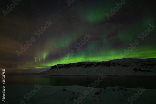 Bright and wavy aurora of the fjord