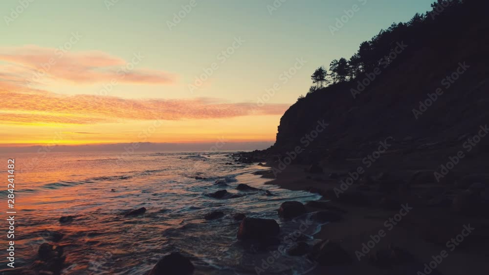 Sea sunrise and tropical exotic beach with cliffs and stones in the water Sea sunrise and tropical exotic beach with cliffs and stones in the water