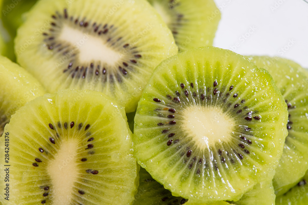 Many kiwi slices are placed in a glass crisper. Kiwifruit slices without peel. Many kiwi slices are placed in a glass crisper. Kiwifruit slices without peel.