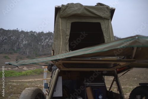 View of roof rack tent and awning on 4x4 car against mountain