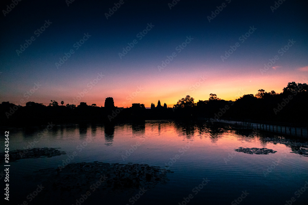 Angkor Wat Temple in Cambodia with sunset (Dawn) skies with the reflection of a religious monument of architecture.