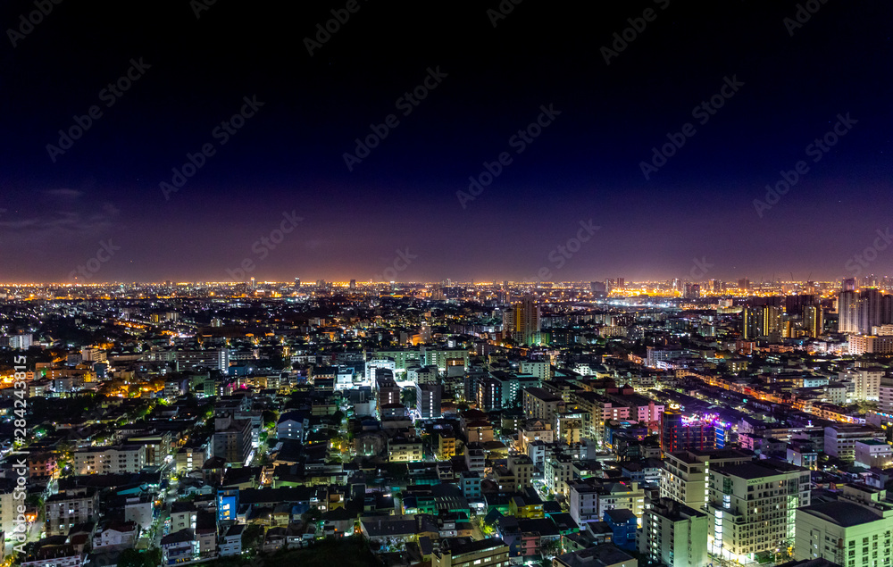 Bangkok cityscape at nighttime with street lights and dark sky.