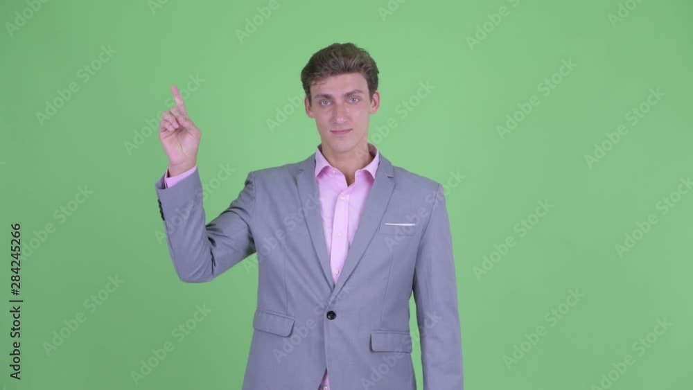 Happy young businessman pointing up Happy young businessman pointing up