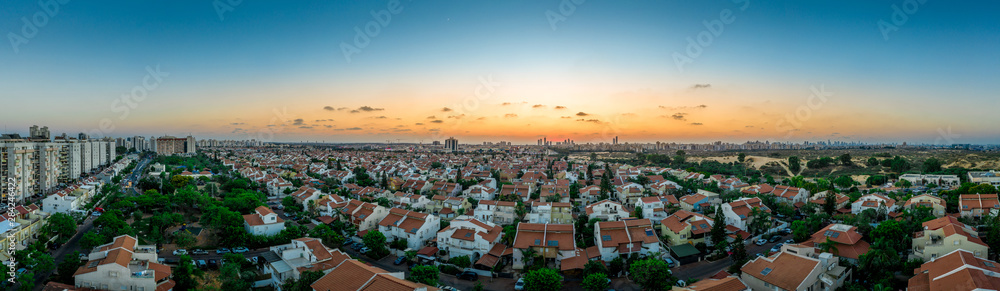 Sunset over Rishon Lezion, Bat Yam and the Tel Aviv skyline with typical middle class Israeli single family homes