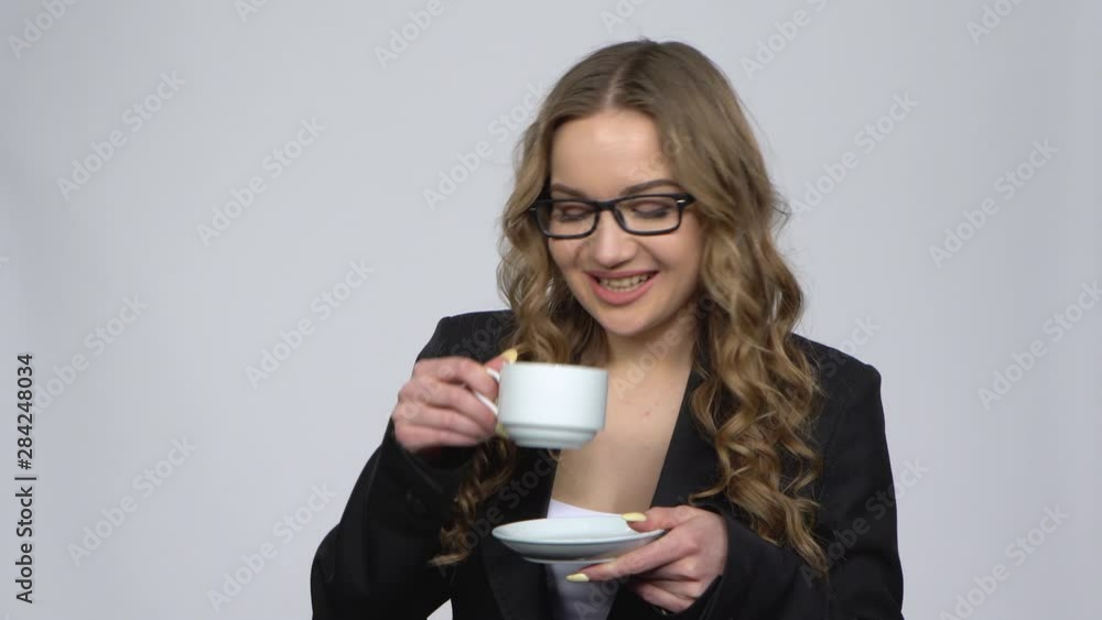 Office worker woman drinking coffee and smiling talking with someone Office worker woman drinking coffee and smiling talking with someone