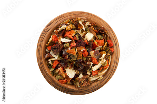 Mixing slices of pepper in a clay cup isolated on a white background. View from above. Dry spices. Seasonings on isolate.