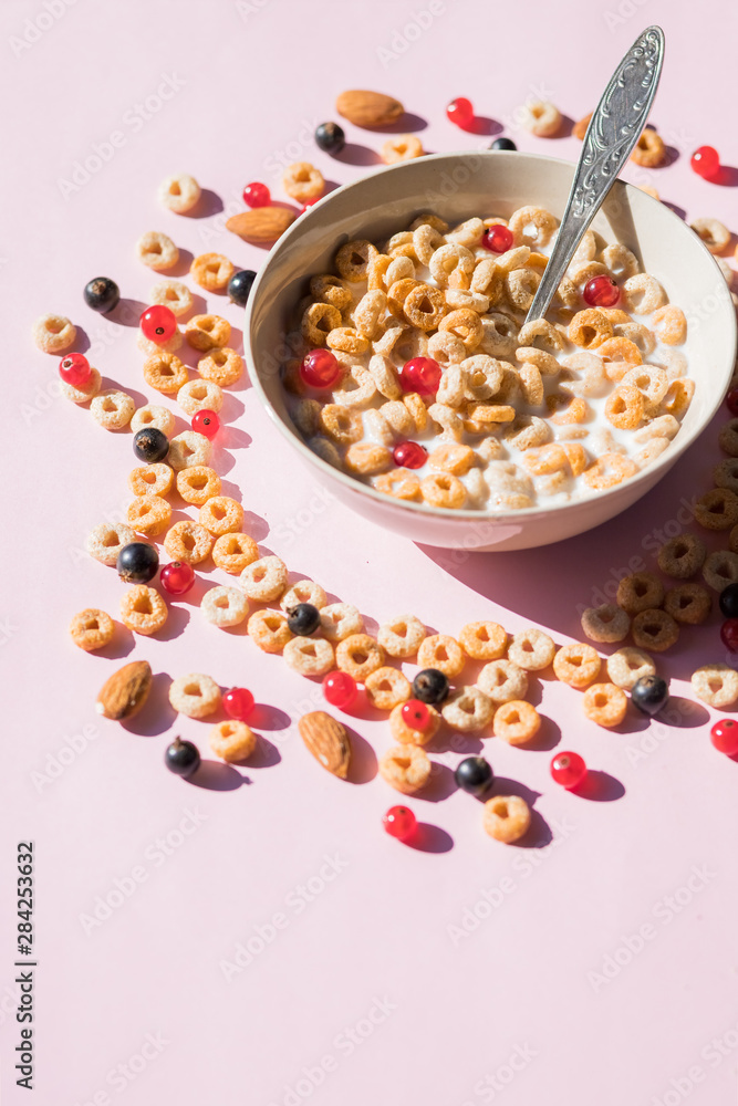 wholegrain flakes with berries and milk on pink. Healthy tasty breakfast cornflakes with blueberries, raspberries and red currant.Multigrain wholewheat healthy cereals with fresh berry. wholegrain flakes with berries and milk on pink. Healthy tasty breakfast cornflakes with blueberries, raspberries and red currant.Multigrain wholewheat healthy cereals with fresh berry.