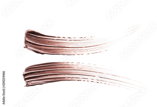 Brown strokes and texture of cream eyeshadow or acrylic paint isolated on white background