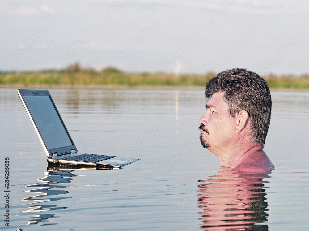 Man with the laptop in water, distant work