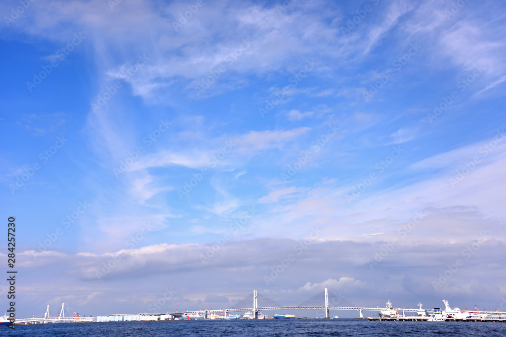 Fototapeta premium 白い雲が浮かぶ横浜港とベイブリッジ