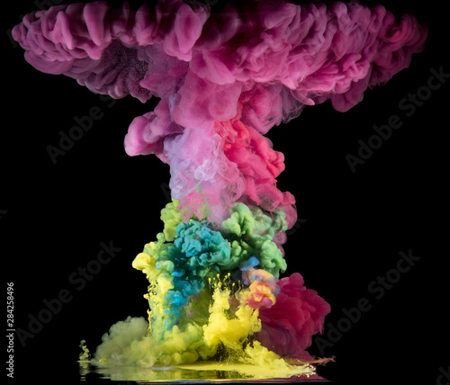 Colorful paint drops from above mixing in water. Ink swirling underwater