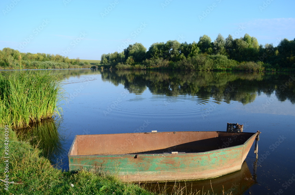 fishing boat in a calm lake water at morning