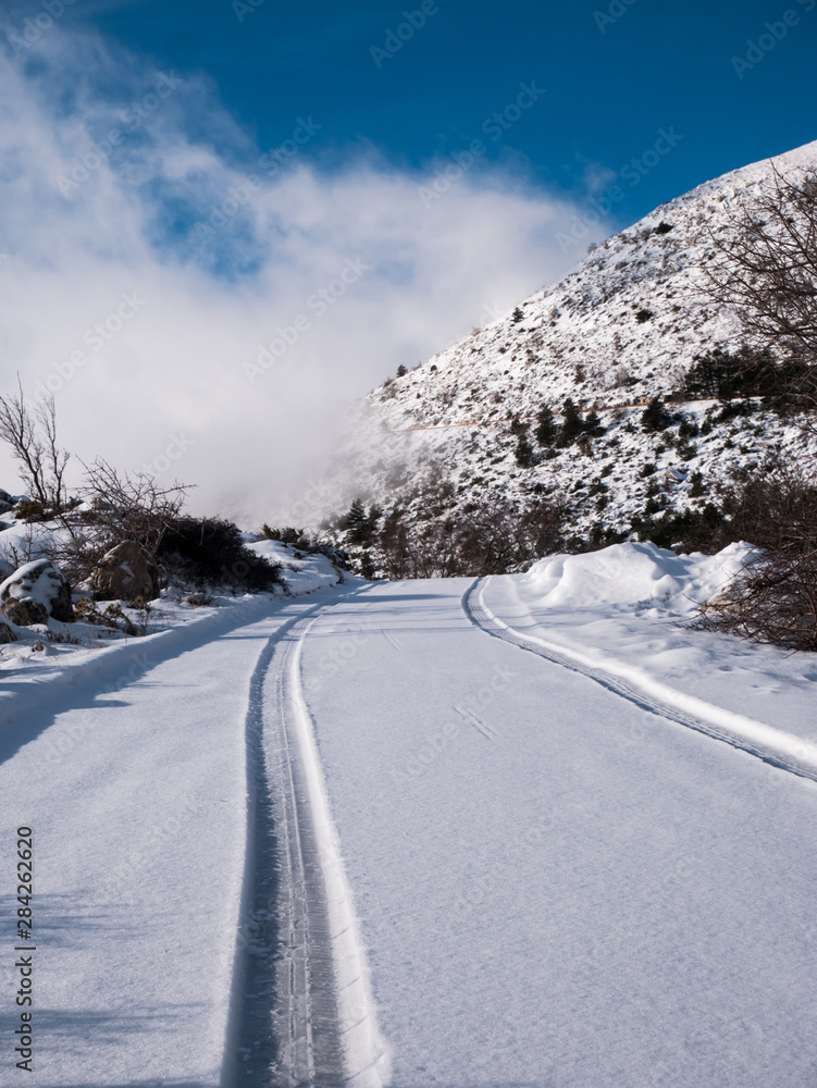 Path in snow covered mountain road on sunny day Path in snow covered mountain road on sunny day