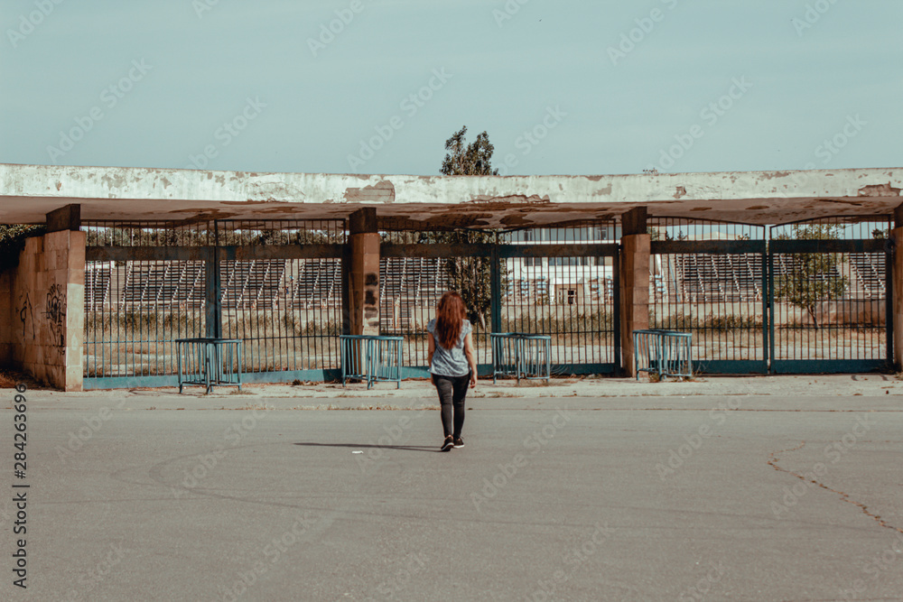 Girl in old abandoned ghost town bus station.