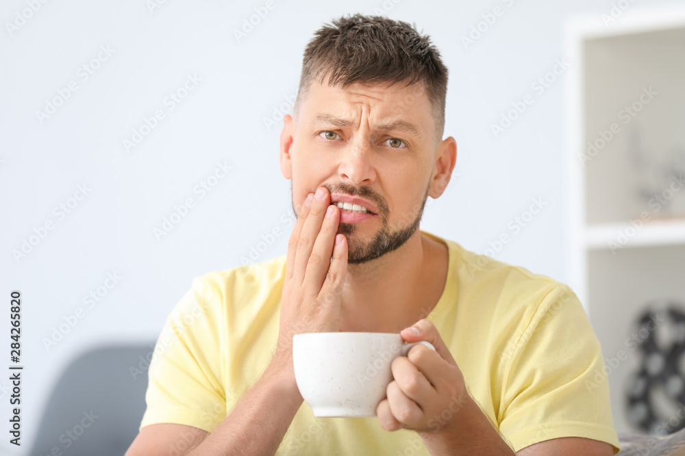 Man with sensitive teeth and hot coffee at home Man with sensitive teeth and hot coffee at home