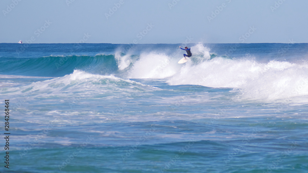 Surfers on clear cold winter morning at Trigg Beach Western Australia