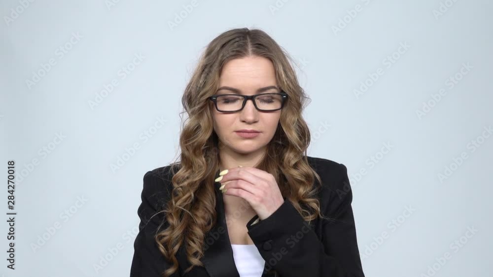 Woman speaking via telephone looking bored on gray background at studio, slow motion. Woman speaking via telephone looking bored on gray background at studio, slow motion.