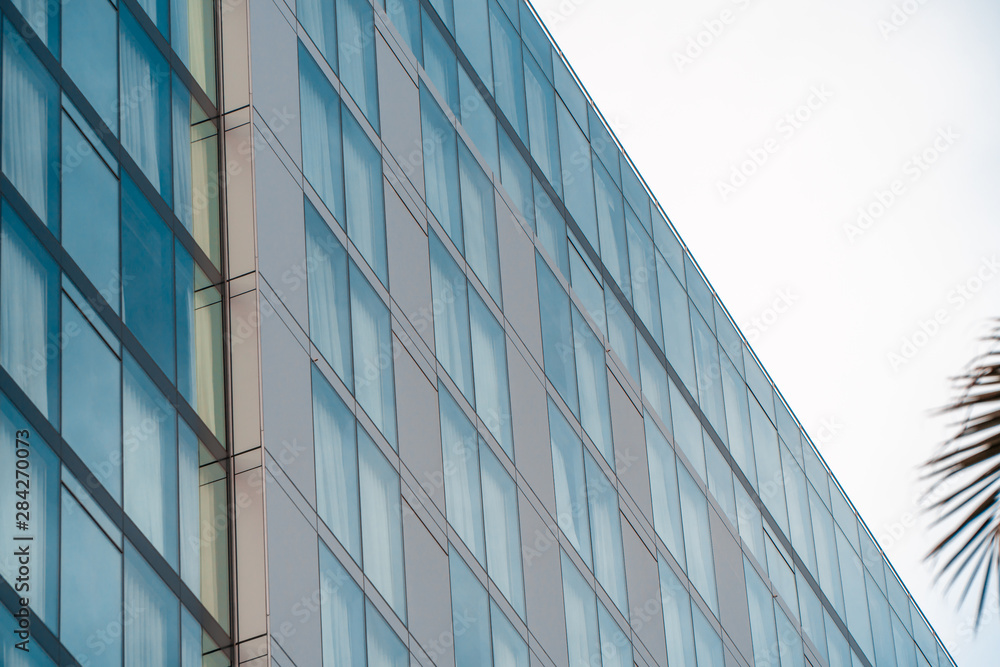Real estate lease concept. Blue windows of office building close up