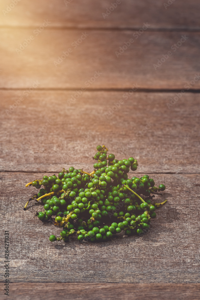 fresh green pepper corns in vine on wooden table fresh green pepper corns in vine on wooden table